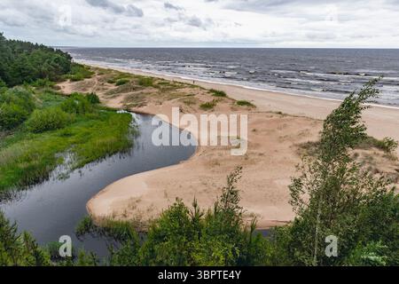 Blick auf die Weiße Düne in Saulkrasti, Lettland, an der Küste des Golfes von Vidzeme, an der Ostsee mit dem rauen Meer und dem bewölkten Himmel im Hintergrund Stockfoto