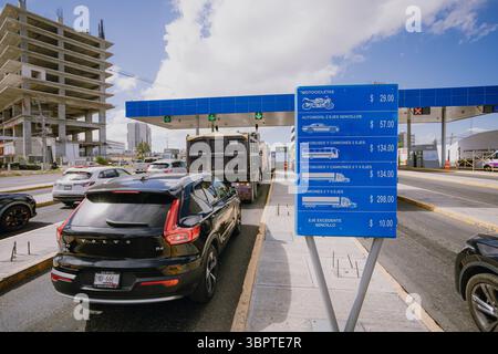 An der Mautstelle von Atlixcáyotl in Puebla, Mexiko, stehen Autos, die an einem regulären Tag Verkehrsschilder und Straßenverkehrsgebühren anzeigen Stockfoto