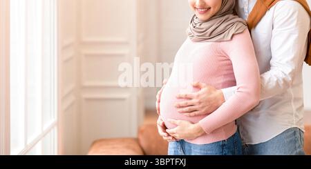 Muslim Paar wartet auf EIN Baby, umarmt stehen zu Hause Stockfoto