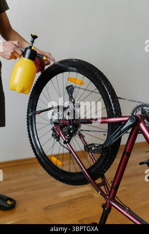 Vertikaler Schuss des männlichen Waschrads mit handgeführtem Wassersprühgerät für Sauberkeit und Wartung. Stockfoto