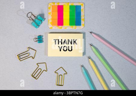 Junger gutaussehender kaukasier isoliert auf gelbem Hintergrund, der ein Plakat mit Text hält, DANKE mit Daumen nach oben Stockfoto