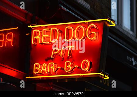 Großes rot-gelbes Restaurantschild in Soho, Werbung für Grillgerichte, London, England, Großbritannien. Stockfoto