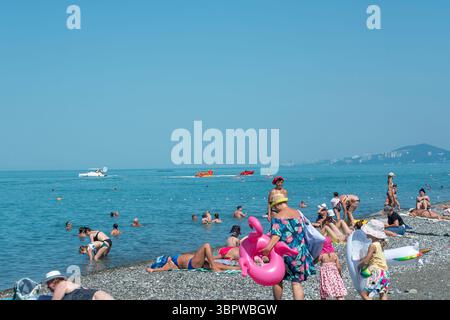 Sotschi, Russland - 05. Juli 2022: Touristen entspannen sich am Strand der Stadt am Meer. Touristische Erholung am Strand eines Sommerresorts. Stockfoto