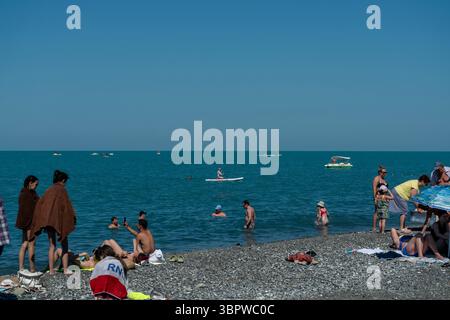 Sotschi, Russland - 05. Juli 2022: Touristen entspannen sich am Strand der Stadt am Meer. Touristische Erholung am Strand eines Sommerresorts. Stockfoto