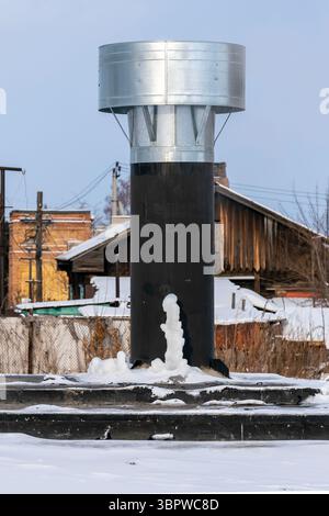 Lüftungsleitung auf dem Dach des Gebäudes. Rohr auf dem Dach im Winter. Stockfoto