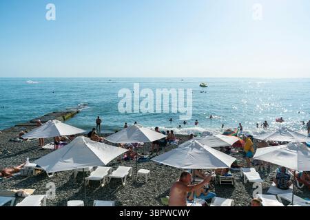 Sotschi, Russland - 05. Juli 2022: Stadtstrand am Meer mit Liegestühlen und Sonnenschirmen. Stockfoto