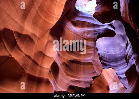 Das Sonnenlicht durchströmt den mehrschichtigen Sandstein im Antelope Canyon und offenbart sich in rot und orange gewundenen Wänden mit Wüstentexturen und zeitloser Schönheit. Stockfoto