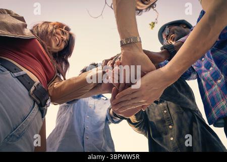 Nahaufnahme einer vielfältigen Gruppe junger Menschen, die ihre Hände in der Mitte zusammenlegen, symbolisieren Teamarbeit, Einheit, Unterstützung, Vertrauen, und suc Stockfoto