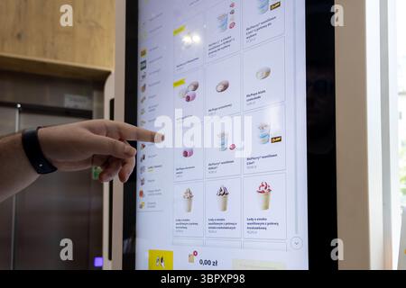 Poznan, Polen – 18. Juni 2025: McDonald's Self-Service Kiosk, ein Kunde, der Menüelemente selbst auswählt und effiziente digitale Bestellungen und Moder präsentiert Stockfoto