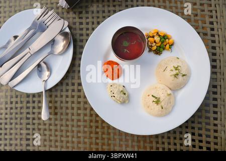 Klassisches südindisches Frühstück. Weiches Idlis serviert mit Kokos-Chutney und aromatischem Sambar. Idli Sambar auf hellem Hintergrund mit Kopierraum. Stockfoto