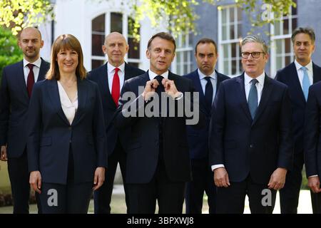 Frankreichs Präsident Emmanuel Macron passt seine Bindungen an und posiert für ein Familienfoto mit dem britischen Premierminister Keir Starmer, dem französischen Minister für Europa und Auswärtige Angelegenheiten Jean-Noel Barrot, Rachel Reeves, Finanzkanzler, dem französischen Innenminister Bruno Retailleau, dem britischen Verteidigungsminister John Healey, dem französischen Minister der Streitkräfte Sebastien Lecornu, dem britischen Staatssekretär für Energiesicherheit und Net Zero Ed Miliband während des Gipfels 10 in London. als Teil seines dreitägigen Staatsbesuchs in Großbritannien am 10. Juli 2025. Foto von Gon Stockfoto