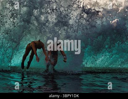 Abenteuerlustige Paare tauchen in natürliche Küstenbecken ein, um massiven Wellen zu entkommen, Charco de Isla Cangrejo, Teneriffa, Kanarische Inseln, Spanien Stockfoto