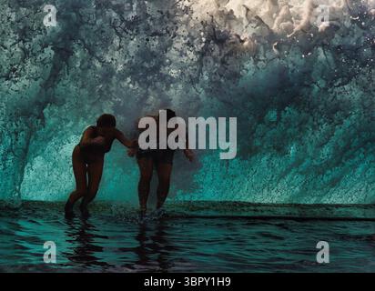 Abenteuerlustige Paare tauchen in natürliche Küstenbecken ein, um massiven Wellen zu entkommen, Charco de Isla Cangrejo, Teneriffa, Kanarische Inseln, Spanien Stockfoto