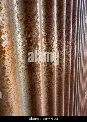 Nahaufnahme der gewellten Metallwandstruktur mit Rostfarbe Stockfoto