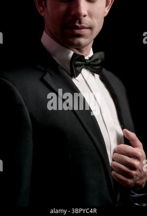 Ein Mann im Smoking passt seine Jacke an. Stockfoto