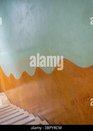 Die abstrakten, organischen Linien der gemalten Wände nach dem Abstieg einer Treppe in Antoni Gaudí Casa Milà, Barcelona, Spanien. Stockfoto