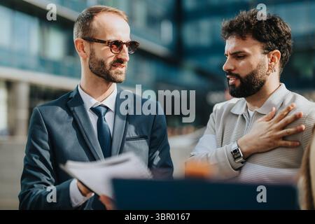Zwei professionelle Männer, die sich im Freien in einer Stadt unterhalten Stockfoto