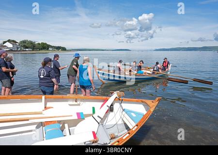 Stranraer, Galloway, Schottland, Großbritannien - SkiffieWorlds - Donnerstag, 10. Juli 2025 – über 2.000 Teilnehmer aus 79 Küstenruderclubs aus ganz Großbritannien und Australien, Südafrika, den Niederlanden, Kanada und den USA nehmen an Rennbooten auf einem 2 km langen Küstenkurs am Loch Ryan Teil – das lokale Wetter war heute über 23c und stellte eine zusätzliche Herausforderung dar. SkiffieWorlds endet am Samstag, den 12. Juli 2025. Foto Steven May / Alamy Live News Stockfoto