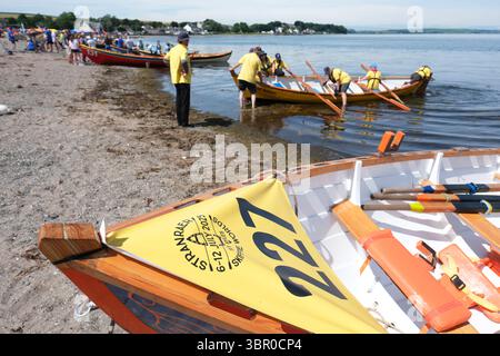 Stranraer, Galloway, Schottland, Großbritannien - SkiffieWorlds - Donnerstag, 10. Juli 2025 – über 2.000 Teilnehmer aus 79 Küstenruderclubs aus ganz Großbritannien und Australien, Südafrika, den Niederlanden, Kanada und den USA nehmen an Rennbooten auf einem 2 km langen Küstenkurs am Loch Ryan Teil – das lokale Wetter war heute über 23c und stellte eine zusätzliche Herausforderung dar. SkiffieWorlds endet am Samstag, den 12. Juli 2025. Foto Steven May / Alamy Live News Stockfoto