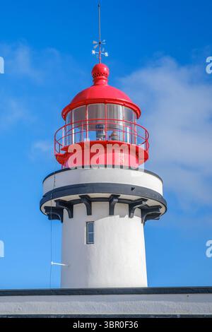 Historischer Red-White Lighthouse Tower Mit Wetterfahne Gegen Blue Sky. Küstenschifffahrtsfeuer, maritime Architektur, nautisches Wahrzeichen, Seasi Stockfoto