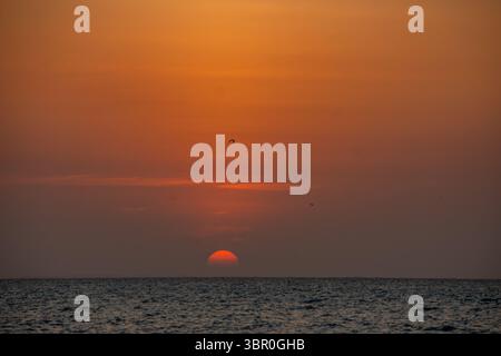 Atemberaubender Blick auf den Sonnenuntergang über das Karibische Meer in Playa Blanca, Cartagena, Kolumbien, perfekt für Urlaubs- und Tourismusbilder. Stockfoto