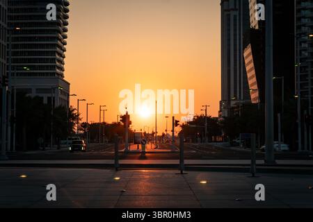 Leere Stadtlandschaft ohne Menschen an der Kreuzung von 5th Avenue und 23rd St in New York City mit Sonnenuntergang zwischen den Gebäuden im Hintergrund Stockfoto