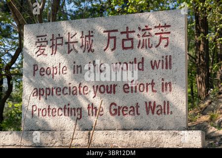 Steinschild aus nächster Nähe mit Zitat auf der Chinesischen Mauer von Mutianyu, UNESCO-Stätte, antike Architektur und kulturelles Wahrzeichen der historischen chinesischen Festung in Asien Stockfoto