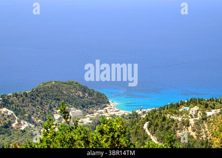 Atemberaubender Blick aus der Luft auf Agios Nikitas Dorf, Lefkada. Das türkisfarbene Ionische Meer trifft auf üppig grüne Hügel und bezaubernde Gebäude. Stockfoto
