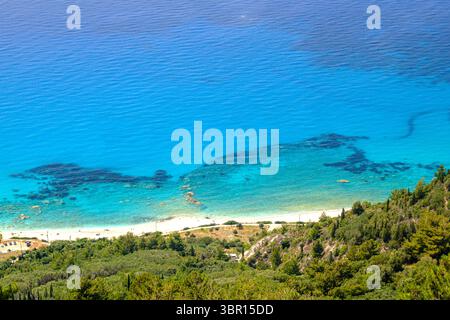 Atemberaubende Aussicht auf die unberührte Küste von Lefkada aus der Vogelperspektive. Üppige grüne Hügel treffen auf einen weißen Strand und kristallklares türkisfarbenes Wasser. Stockfoto