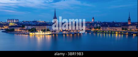 Stockholm, Schweden - 4. Juni 2025: Panoramablick auf die Skyline der Stadt Stockholm in der Abenddämmerung, beleuchtete Gebäude und Reflexionen entlang des Ufers. Stockfoto