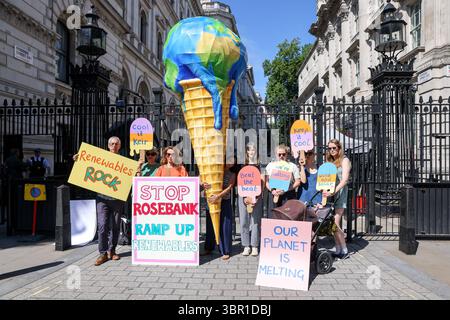 Mitglieder der Mütter protestieren vor der Downing Street in London mit einem riesigen, planetenförmigen Eiskegel, der die Regierung auffordert, die Erschließung des Ölfeldes in Rosebank abzulehnen und die Expansion der Öl- und Gasförderung in der Nordsee zu stoppen. Die Demonstration fällt mit der Veröffentlichung eines Berichts zusammen, der den vom Menschen verursachten Klimawandel mit verstärkten Hitzewellen in ganz Europa in Verbindung bringt, so die Gruppe. Stockfoto