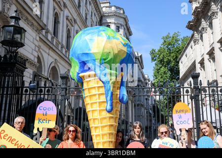 Mitglieder der Mütter protestieren vor der Downing Street in London mit einem riesigen, planetenförmigen Eiskegel, der die Regierung auffordert, die Erschließung des Ölfeldes in Rosebank abzulehnen und die Expansion der Öl- und Gasförderung in der Nordsee zu stoppen. Die Demonstration fällt mit der Veröffentlichung eines Berichts zusammen, der den vom Menschen verursachten Klimawandel mit verstärkten Hitzewellen in ganz Europa in Verbindung bringt, so die Gruppe. Stockfoto