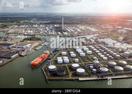 Luftaufnahme von Eine große orange Öltanker in einem Öllager silo Terminal in einem industriellen Hafen vertäut. Stockfoto