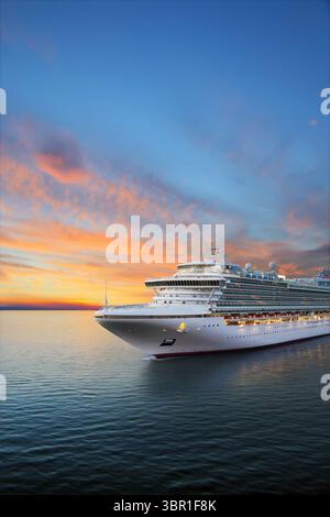 Luxuriöses Kreuzfahrtschiff, das bei Sonnenaufgang zum Hafen fährt Stockfoto