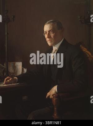 Formelles Porträt von Präsident Woodrow Wilson von Edmund Charles Tarbell, gemalt um 1920–1921. Das Gemälde zeigt Wilson, der mit Stift in der Hand an einem Schreibtisch sitzt, einen dunklen Anzug und eine Brille trägt, während er in die Ferne blickt. Stockfoto
