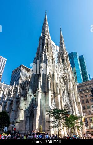 New York, NY - USA - 6. Juli 2025 die St. Patrick's Cathedral erhebt sich in neogotischer Pracht inmitten der Glastürme der Midtown, ihrer Türme und der prunkvollen Fassade Stockfoto