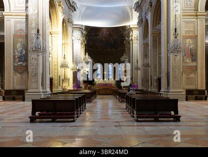 Barocke Kircheneinrichtung mit Freskenapse, Kronleuchtern, Bänken und Buntglasfenstern in der Kathedrale von Ferrara, Emilia-Romagna, Italien. Stockfoto