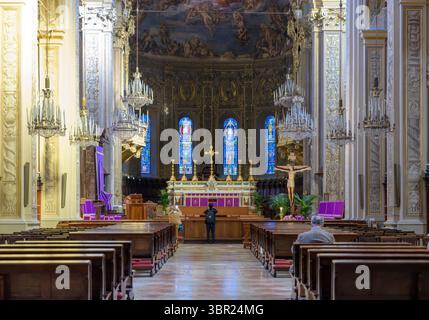 Barocke Kircheneinrichtung mit Freskenapse, Kronleuchtern, Bänken und Buntglasfenstern in der Kathedrale von Ferrara, Emilia-Romagna, Italien. Stockfoto