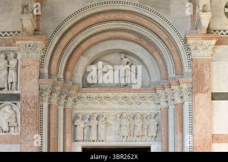 Romanische Marmor-Lünette, die das Martyrium des heiligen Regulus über einem Portal der Kathedrale San Martino in Lucca, Italien, darstellt. Stockfoto