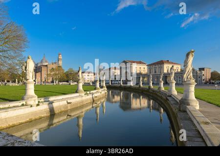 Prato della Valle ist ein großer Platz in Padua, Italien, mit einer zentralen elliptischen Insel, umgeben von einem Kanal und Statuen. Stockfoto