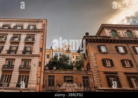 Am späten Nachmittag werden italienische Fassaden von Apartmentgebäuden aus dem frühen 20. Jahrhundert im historischen Zentrum des alten Roms durch Licht gewaschen, die reich verzierte Balkone freigeben, die verschlossen sind Stockfoto
