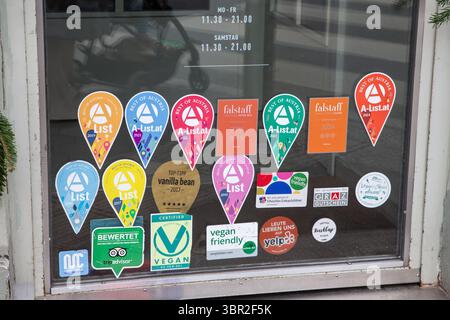 GRAZ, ÖSTERREICH - 17. DEZEMBER 2024: Tür in Graz mit Einer Liste Best of Austria Pins, Falstaff Plakaten und veganen freundlichen Logos zeigen, wie Restaurants fla Stockfoto
