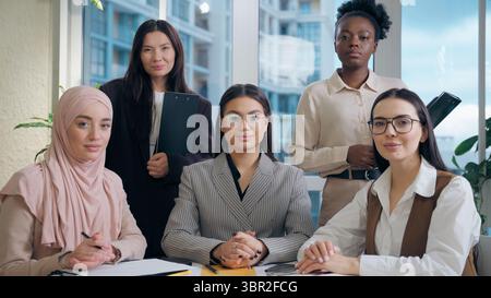 Glückliche multiethnische Afroamerikaner Japaner Kaukasier Indisch Arabische Muslime Frauen Diversität Team Mädchen Gruppe Kollegen Geschäftsfrauen winken Stockfoto