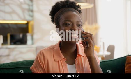 Lachen glückliche afroamerikanische ethnische Frau weibliches Model Dame Hausbesitzer Klient spricht Handy Gespräch Lächeln Lachen freundlich Talk Anruf Stockfoto
