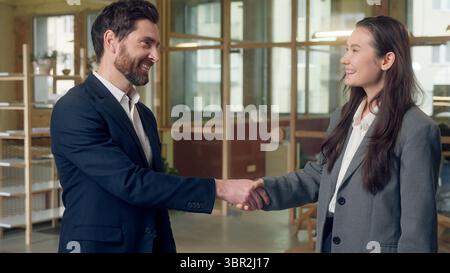 Kaukasischer Koreaner zwei verschiedene Geschäftsleute Handshake Geschäftsteam schüttelnde Hände Partnerschaft glückliche Unternehmer Frau Mann Grußgeste Stockfoto