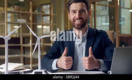 Erfolgreicher lächelnder kaukasischer Geschäftsmann präsentiert Umweltprojekt Windmühlen grüne Energie Modelle Laptop arbeiten Generator Energie Umwelt zeigen Stockfoto