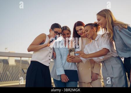 Eine Gruppe enger Freunde, die ihre gemeinsame Zeit auf einem wunderschönen Dach genießen Stockfoto