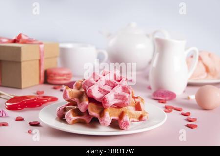 Hausgemachte rosa Waffeln mit Schlagsahne. Valentinstag, Muttertag-Konzept. Leckeres Frühstück Stockfoto
