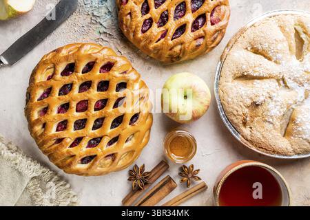 Verschiedene hausgemachte Kuchen mit Zutaten. Crostata - offene Berry pie und Apfelkuchen auf eine Tabelle, Ansicht von oben, von oben Stockfoto