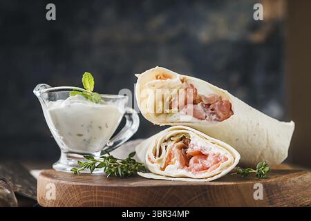 Frische Tortilla Wrap mit Gemüse und Lachs auf Holz Schneidebrett Stockfoto